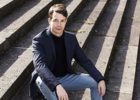 Florian Strötz sitzt auf einer Treppe